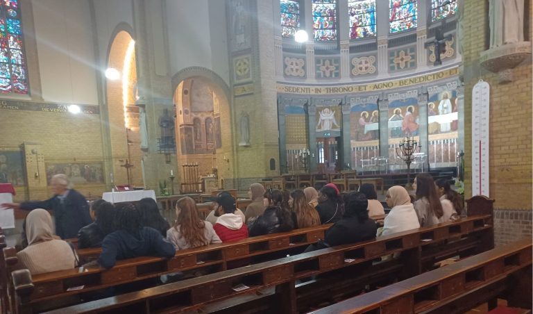 leerlingen zitten in de kerkbanken van een katholieke kerk