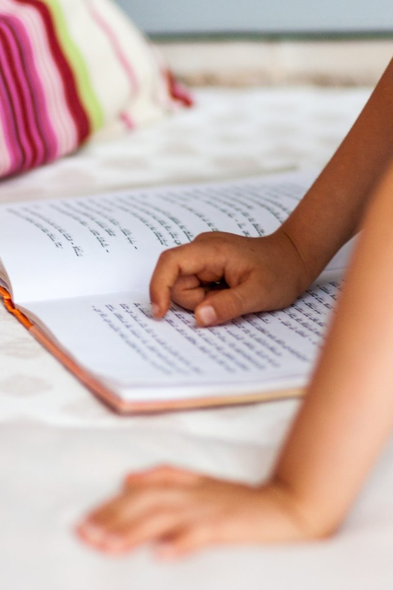 Kind wijst met vinger in een Hebreeuw boek