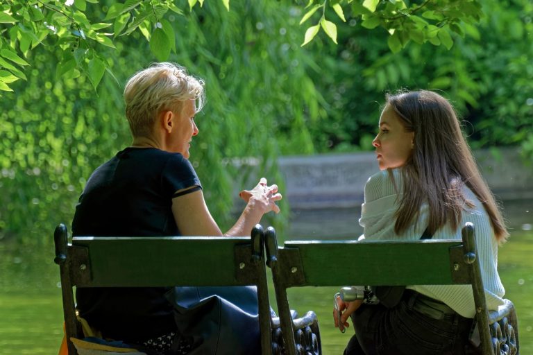 vrouw en jonge vrouw in gesprek op een bankje in een park