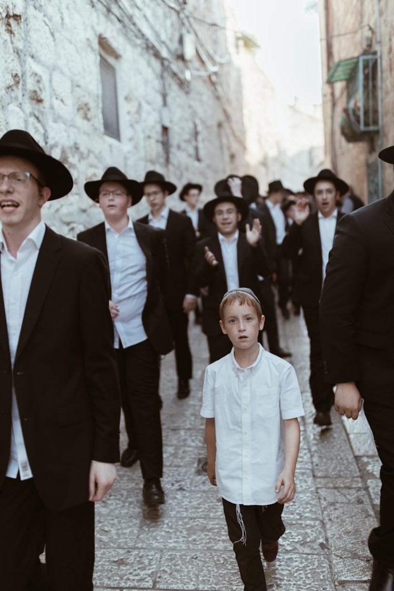 een groep joodse mannen met één jonge jongen wandelen op straat