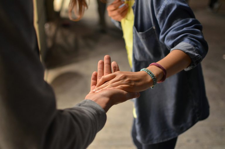 man en vrouwen pakken elkaars hand op straat