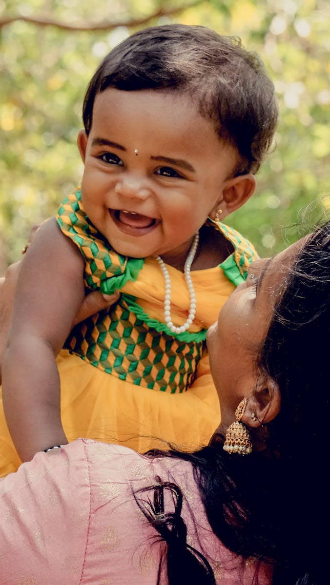 A Woman Holding Her Little Daughter and Smiling